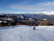 Breite Piste und Dolomitenpanorama
