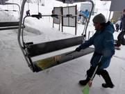 Der Sitz wird am Einstieg mit einem Besen von Schnee freigefegt