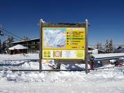 Informationstafel mit Pistenplan im Skigebiet
